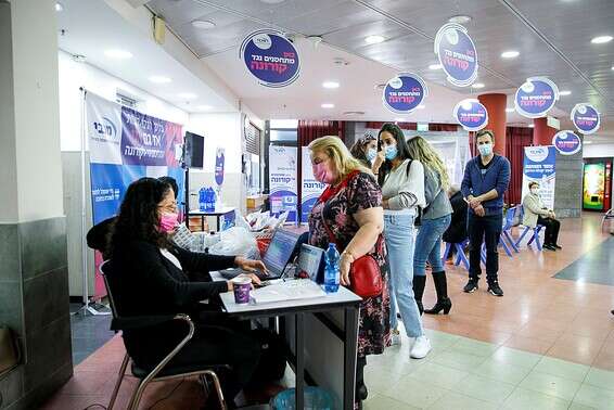 אנשים ממתינים בתור לקבלת החיסון לקורונה באשדוד, אתמול // צילום: לירון מולדובן