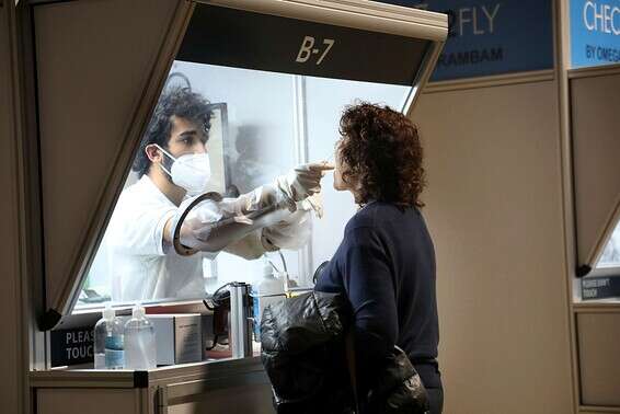 אישה עוברת בדיקת קורונה בנתב"ג, בראשון // צילום: גדעון מרקוביץ'