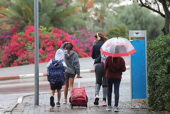 ילדים בדרך לבית ספר בזמן הגשם // צילום: יהונתן שאול