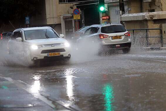 רכבים חוצים רחוב מוצף בחיפה // צילום: הרצי שפירא