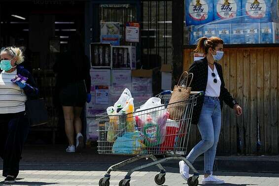 אישה יוצאת מסופר בשדרות בו ביצעה קניות לביתה, באפריל // צילום: יהודה פרץ