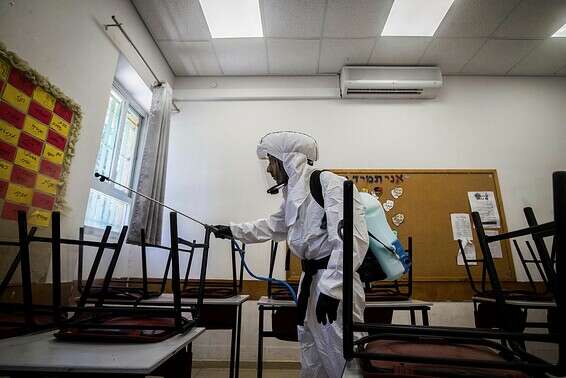 מתכוננים לפתיחה מחדש. חיטוי כיתה // צילום: אורן בן חקון