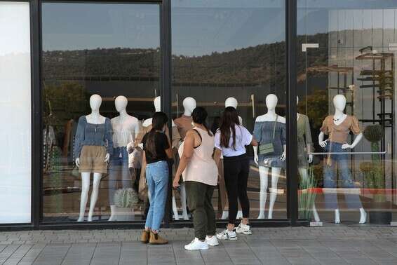 נשים מסתכלות על חנות בגדים שנסגרה, בכרמיאל, בשבוע שעבר // צילום: דוד כהן, ג'יני